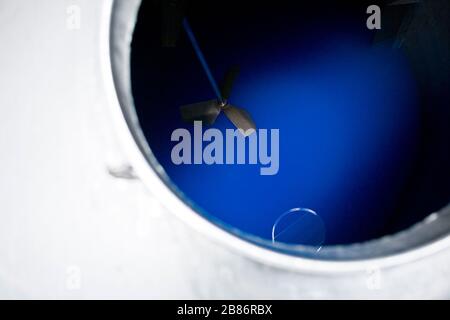 Reinigen Sie das Produkt in einen großen Aluminiumbehälter, der in Flaschen abgefüllt werden kann Stockfoto