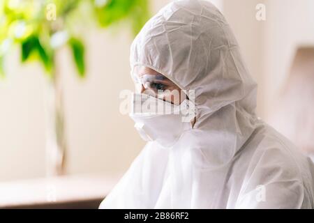 Eine Frau mit Schutz gegen eine Pandemie oder einen Virus, die eine Maske und eine Brille trägt Stockfoto