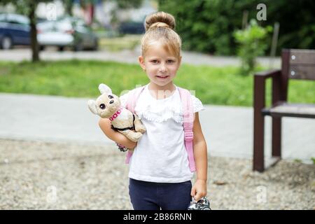 Kleines Mädchen hält ein Spielzeug. Zurück zur Schule. Das Konzept von Schule, Studium, Bildung, Kindheit. Stockfoto