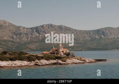 Großes Haus auf der Insel mit Bergen im Hintergrund Stockfoto