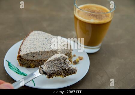 Hausgemachtes Dessert mit Mohn. Wüste aus Mohn, ohne Mehl und Zucker. Geeignet für karbarme Ernährung. Kaffee mit Milch ist ebenfalls im Preis inbegriffen. Stockfoto