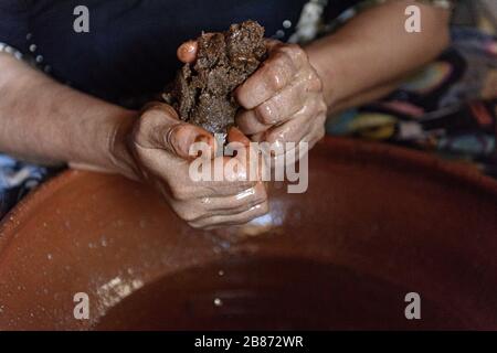 Essaouria, Marokko - September 2017: Argan-Öl von Hand machen - Zellstoff zusammendrücken, um Öl freizulassen Stockfoto