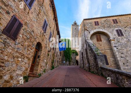 San Gimignano, Toskana: Ein Blick auf eine Straße im historischen Zentrum, die sich nach oben zum höchsten Turm namens Torre Grossa erhebt. Stockfoto