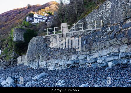 Dollars Mills Sea Wall und Lime-Brennofen-Blick. Looking Inland mit Cliff Top Houses und detaillierten defensiven Steinmetzarbeiten an der North Devon Coast. Stockfoto