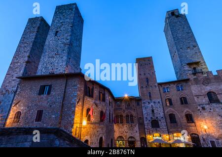 San Gimignano, Toskana: Die Salvucci-Türme (Torri dei Salvucci), Palazzo Vecchio del Podestà, Torre Rognosa und andere Gebäude auf der Piazza del Duomo. Stockfoto