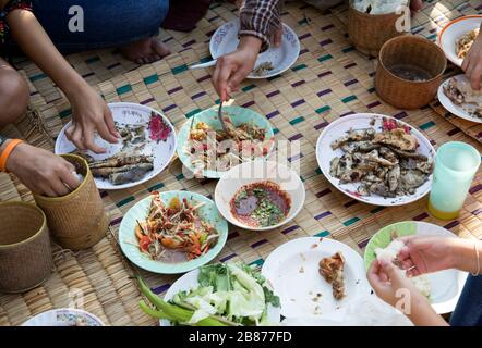 Essen Sie Norteasthern Speisenmenü mit Hand auf Rattan-Matte. Die nordöstliche thailändische Küche ist Somtumgrillfisch und Chilisauce Stockfoto