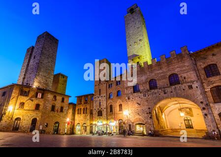 San Gimignano, Toskana: Die Salvucci-Türme (Torri dei Salvucci), Palazzo Vecchio del Podestà, Torre Rognosa und andere Gebäude auf der Piazza del Duomo. Stockfoto