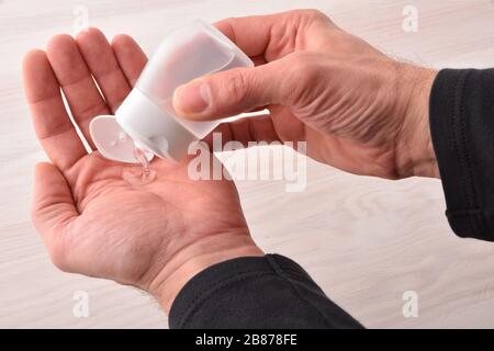 Man wendet Handdesinfiziererflüssigkeit aus Kunststoff-Taschenflasche an. Erhöhte Ansicht. Stockfoto
