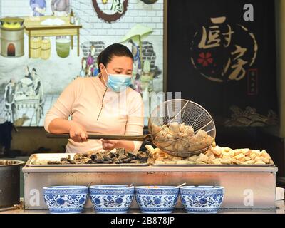 (200320) -- TAIYUAN, 20. März 2020 (Xinhua) -- EIN Mitarbeiter stellt Essen in einer Imbissbar in Taiyuan, Nordchina, Provinz Shanxi, am 19. März 2020 her. Hier in Taiyuan haben sich nach und nach Leben und Produktion unter strengen Maßnahmen zur Prävention und Kontrolle der neuartigen Coronavirus-Epidemie wieder aufgenommen. (Foto von Chai Ting/Xinhua) Stockfoto