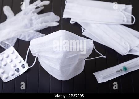 Medizinische weiße Masken auf schwarzem Hintergrund. Chirurgische Schutzmaske gegen Viren und Bakterien. Das Konzept des Schutzes gegen Influenza, Coronav Stockfoto