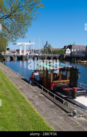 Blick auf einen Kanal mit einem Kahn im Dorf Enkhuizen. Enkhuizen ist wegen seiner Vergangenheit als Zentrum für Heringsfischerei als "Herringstadt" bekannt Stockfoto