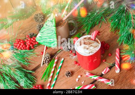 Tasse leckeren Kakaos auf verschwommenem Hintergrund. Heiße Schokolade mit Peitschencreme und Pfefferminzkannen. Heiße Schokolade mit Pfefferminzkäuzen Stockfoto