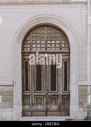Alte hölzerne Vintage gewölbte Eingangstür, verwitterte Oberfläche Stockfoto