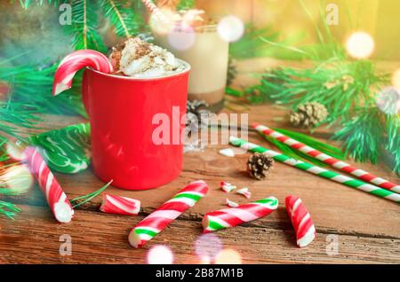 Tasse leckeren Kakaos auf verschwommenem Hintergrund. Heiße Schokolade mit Pfefferminzkäuzen. Hintergrund des Weihnachtsurlaubs. Stockfoto