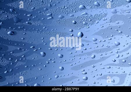 Nahaufnahme von Fingerabdrücken auf nassem Glas mit Tropfen auf blauem Hintergrund. Abstraktes Hintergrundkonzept. Werbefläche Stockfoto