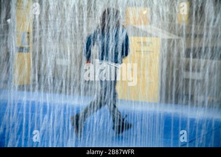 Der Junge spielt und läuft in der Wasserbrunneninstallation South Bank London Stockfoto