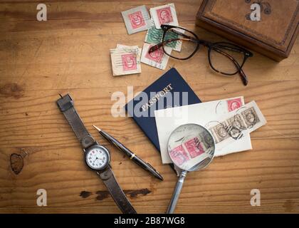 Robustes und maskulines Kiefernholz mit Lederbox, Reisepass, Uhr und Briefmarken mit anderen Herrenzubehör für einen Vatertags-Urlaubslook Stockfoto