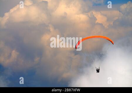 Extreme Erholung, Fallschirmspringer fliegt über die Berge und Felsen. Weiße Wolken am Himmel Stockfoto