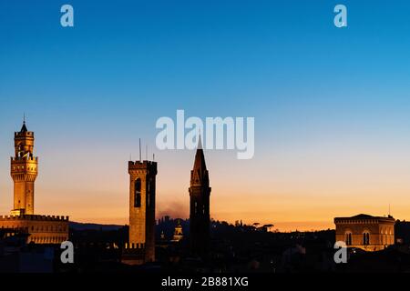 Dachpanorama von Florenz bei Sonnenuntergang während der blauen Stunde mit dem Rathaus Palazzo Vecchio, der Kirche Chiesa Orsanmichele und dem Mond im Himmel Stockfoto