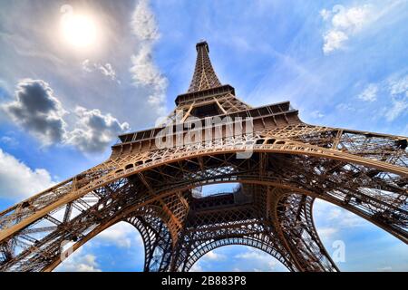 Eiffelturm, Paris, Frankreich mit Blick nach oben, Sonne und lebendiger blauer Himmel Stockfoto