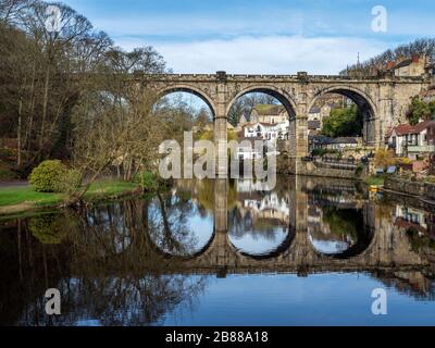 Der viktorianische Eisenbahnviadukt spiegelte sich im frühen Frühjahr im Fluss Nidd in Knaresborough North Yorkshire England wider Stockfoto