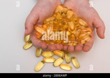 Vitaminen Omega 3 Fischöl in Kapseln in Hand auf beigem Hintergrund. Stockfoto