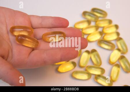 Vitaminen Omega 3 Fischöl in Kapseln in Hand auf beigem Hintergrund. Stockfoto