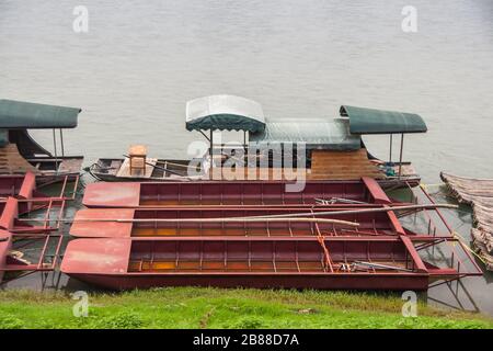 Guilin, China - 11. Mai 2010: Stadtzentrum. 4 Reihen von Rotmetall- und Bambusflößen entlang des grünen Ufers des Flusses Li. Stockfoto