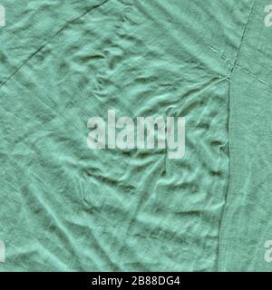 Hintergrundtextur aus türkisfarbenem Stoff. Türkisfarbener Hintergrund aus einem Textilmaterial Stockfoto