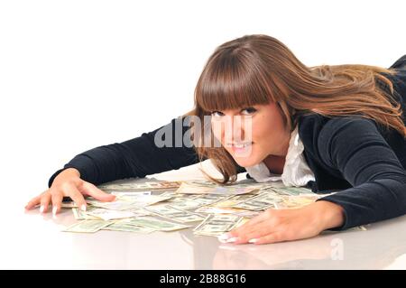 Porträt einer hübschen kaukasischen weißen brünette Frau, die in der Nähe von Euro- und Dollarscheinen liegt. Isoliert auf weißem Hintergrund Stockfoto