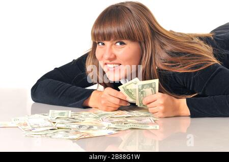 Porträt einer hübschen kaukasischen weißen brünette Frau, die in der Nähe von Euro- und Dollarscheinen liegt. Isoliert auf weißem Hintergrund Stockfoto