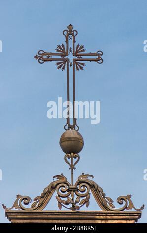 Altes schmiedeeisernes Kreuz im Vordergrund Stockfoto