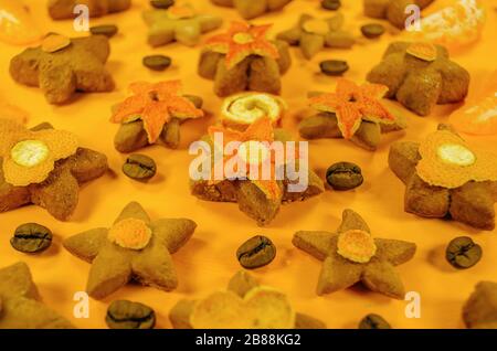 Weihnachten Zucker Cookies in der Form eines Sterns mit kandierten Früchten, Kaffee, Orangenschale auf gelbem Hintergrund Stockfoto