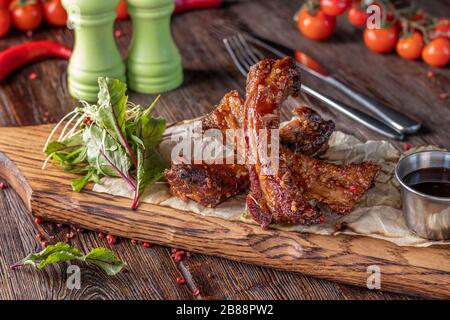 In Sojasoße marinierte, gebackene Schweinerippen auf Holzbrett, Restaurantgericht, horizontale Ausrichtung Stockfoto