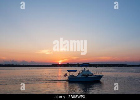 Belmar, NJ, USA - 19. Juli 2017. Ein kleines Boot segelt bei Sonnenuntergang in Shark River an einem Sommertag in Belmar, New Jersey Stockfoto