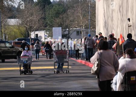 Portland, USA. März 2020. Am 20. März 2020 warten die Menschen in einer langen Reihe auf einen Laden in einem Costco in Portland, Ore. Staatliche Versammlungen sind jetzt auf nicht mehr als 25 Personen beschränkt, und Bars und Restaurants bieten nur Takeout-Dienstleistungen an, da soziale Distanzierungsmaßnahmen darauf abzielen, die Verbreitung des neuartigen Coronavirus (COVID-19) zu verlangsamen und die Kurve zu glätten. (Foto von Alex Milan Tracy/Sipa USA) Credit: SIPA USA/Alamy Live News Stockfoto