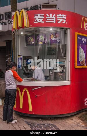 Guilin, China - 10. Mai 2010: Innenstadt von Zhengyang Fußgängerzone. Rote und gelbe McDonalds Dessert Station mit Server und Kunde. Stockfoto