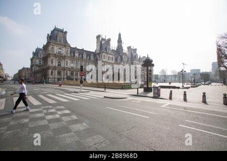 Paris, Frankreich. März 2020. Ein Mann läuft am Nachmittag des 20. März 2020 an einer leeren Rue de Rivoli und dem Hotel de Ville in Paris, Frankreich. Paris ist seit Dienstag auf der Sperrstelle, um die Verbreitung des Coronavirus einzudämmen, wobei die Bürger gezwungen sind, eine Beschattung oder Schreibarbeit zur Erklärung ihrer Ursache für das sein außerhalb zur Verfügung zu stellen. (Foto von Daniel Brown/Sipa USA) Credit: SIPA USA/Alamy Live News Stockfoto