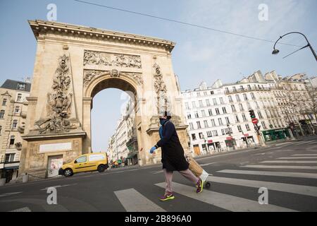 Paris, Frankreich. März 2020. Eine Frau spaziert am Nachmittag des 20. März 2020 an einem desolaten Bogen von Porte Saint-Denis. Paris ist seit Dienstag auf der Sperrstelle, um die Verbreitung des Coronavirus einzudämmen, wobei die Bürger gezwungen sind, eine Beschattung oder Schreibarbeit zur Erklärung ihrer Ursache für das sein außerhalb zur Verfügung zu stellen. (Foto von Daniel Brown/Sipa USA) Credit: SIPA USA/Alamy Live News Stockfoto