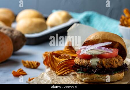 Veganer Kichererbsenburger mit Süßkartoffelchips. Stockfoto