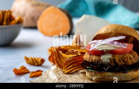 Veganer Kichererbsenburger mit Süßkartoffelchips. Stockfoto