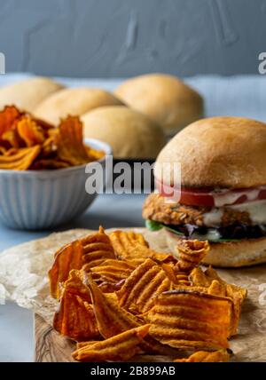 Veganer Kichererbsenburger mit Süßkartoffelchips. Stockfoto