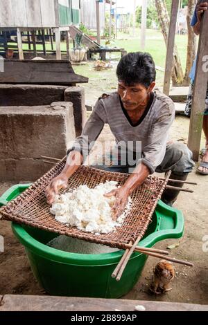 Yuca wird von Menschen in der indischen Gemeinschaft von Cacao Island, Amazon Rain Forest, Peru, Südamerika, gesiebt. Stockfoto