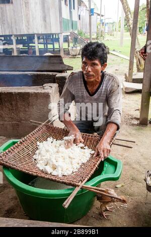 Yuca wird von Menschen in der indischen Gemeinschaft von Cacao Island, Amazon Rain Forest, Peru, Südamerika, gesiebt. Stockfoto