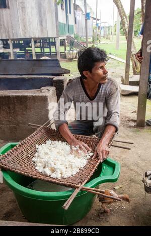 Yuca wird von Menschen in der indischen Gemeinschaft von Cacao Island, Amazon Rain Forest, Peru, Südamerika, gesiebt. Stockfoto