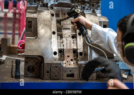 Der Ingenieur friert den Guss mit einer speziellen Maschine, die Wartung von Metallformen für Kunststoffgussteile im Werk Stockfoto