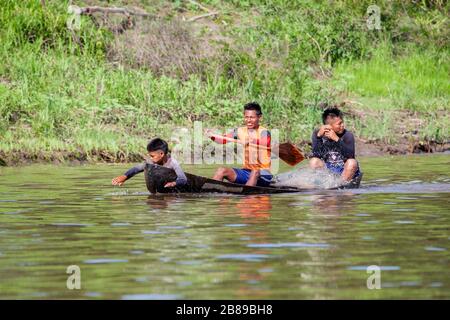 Drei Jungs in einem Dugout am Amazonas-Fluss, Kolumbien, Peru, Südamerika. Stockfoto