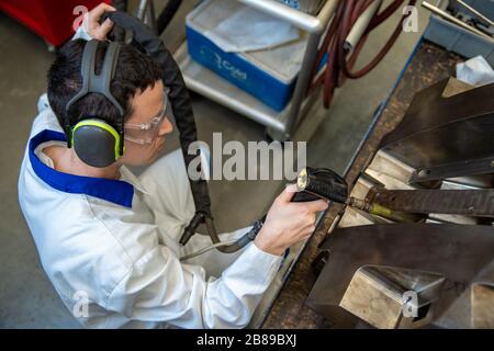 Der Ingenieur friert den Guss mit einer speziellen Maschine, die Wartung von Metallformen für Kunststoffgussteile im Werk Stockfoto