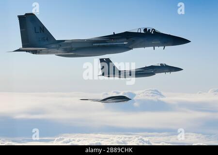 Ein strategischer Kampfflugzeug der U.S. Air Force B-2A Spirit Stealth-Kampfflugzeuge fliegt mit einem F-15C Eagle während der Operationen zur Unterstützung der Bomber Task Force Europe 20-2. März 2020 über Keflavik, Island in Formation. Stockfoto