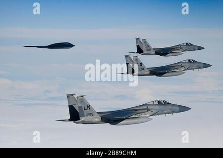 Ein strategischer Kampfflugzeug der U.S. Air Force B-2A Spirit Stealth-Kampfflugzeuge fliegt mit einem F-15C Eagle während der Operationen zur Unterstützung der Bomber Task Force Europe 20-2. März 2020 über Keflavik, Island in Formation. Stockfoto